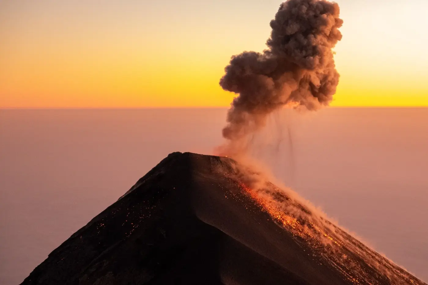 A Guatemalan volcano erupting at sunset