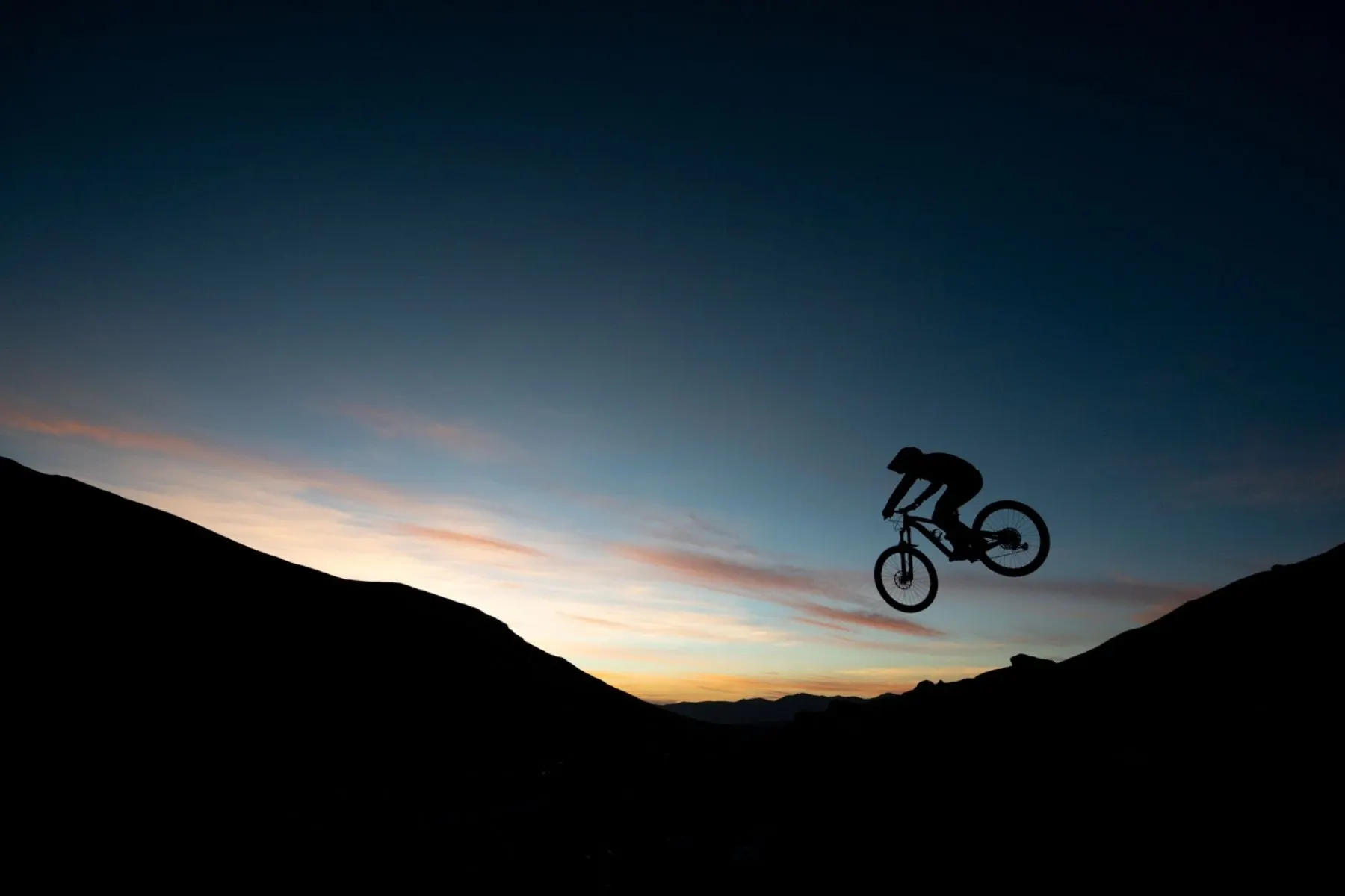 Rider silhouetted on a ridgeline at sunset