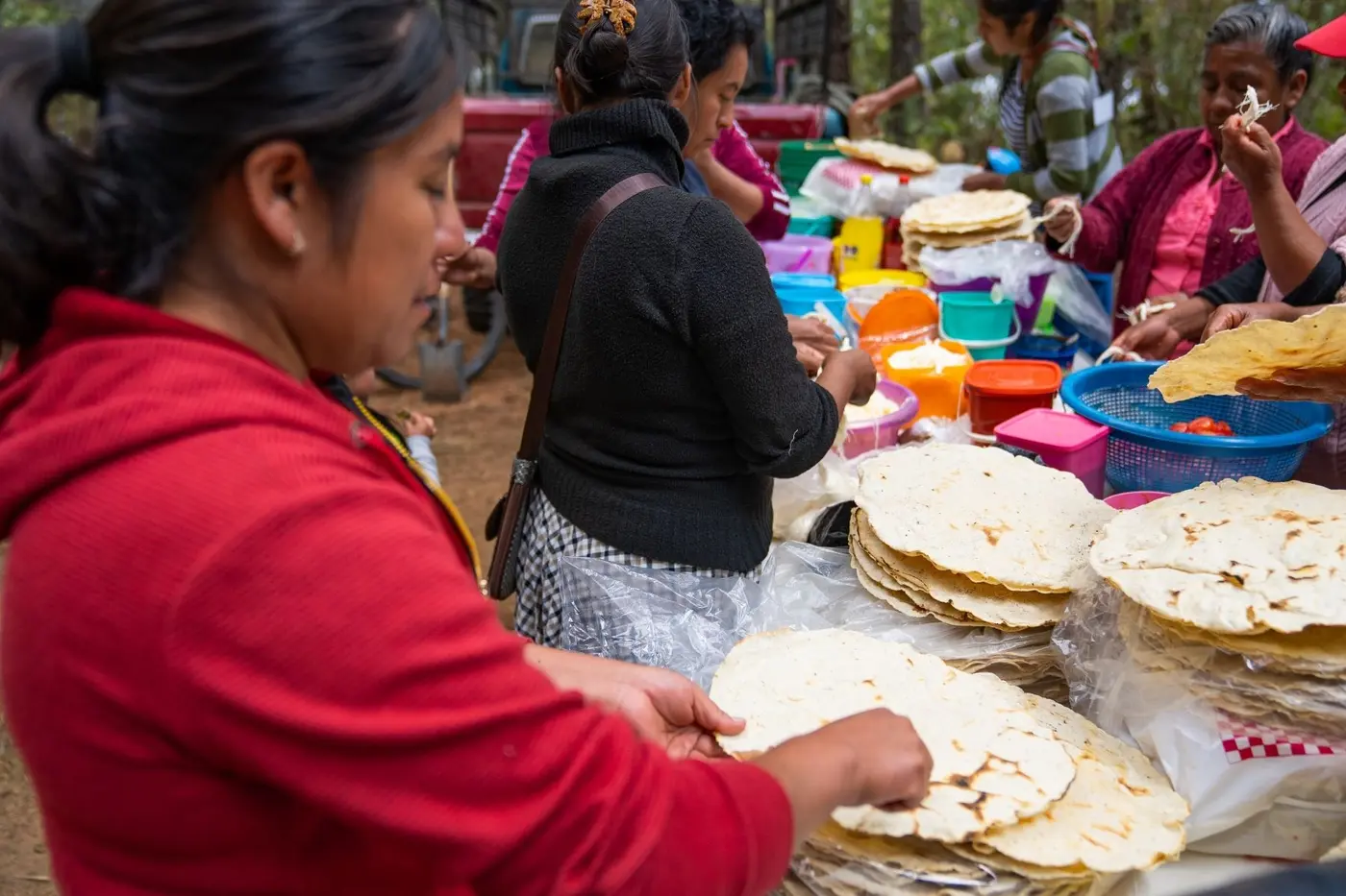 A local cook stacking fresh tortillas at market