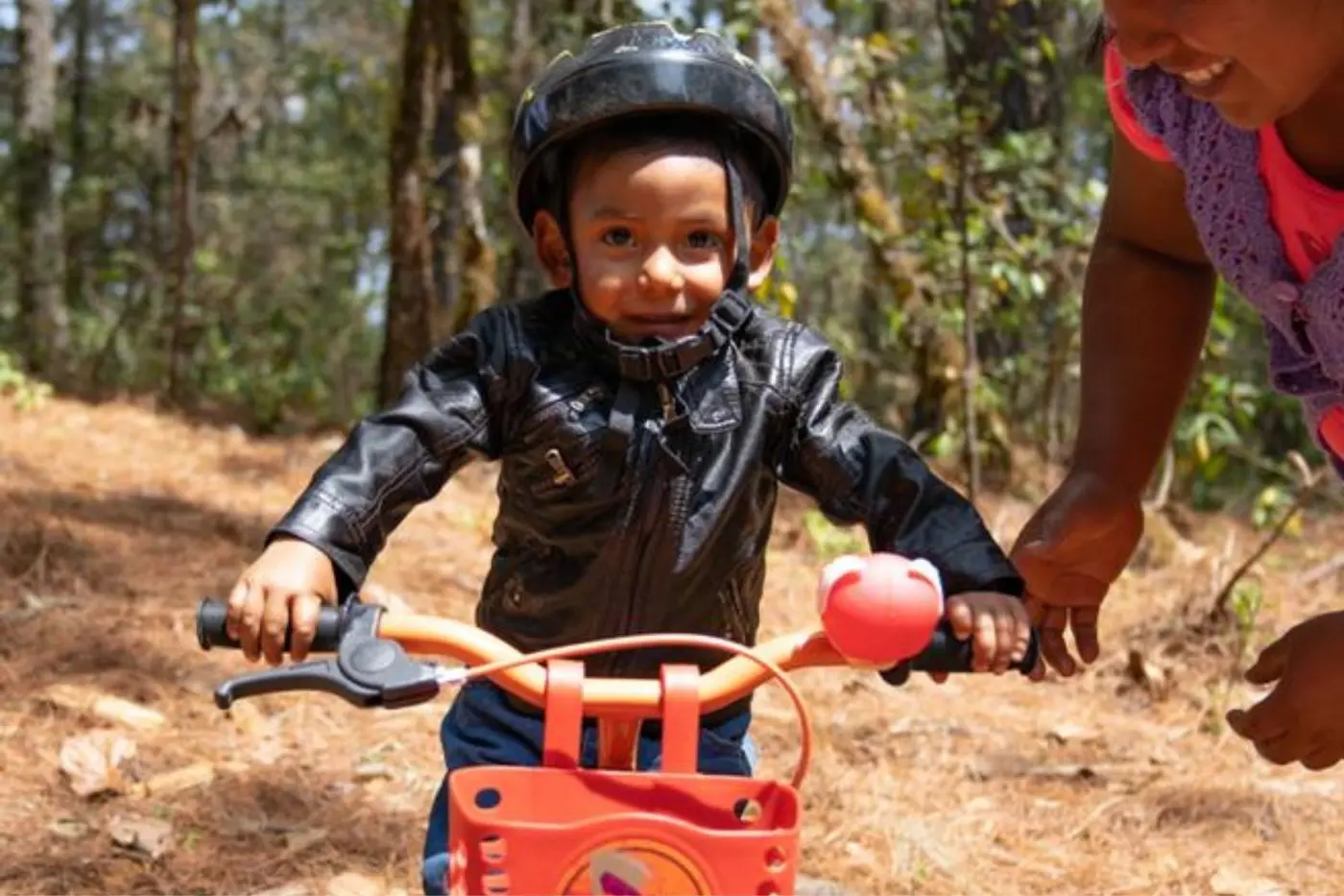 A child grinning on a newly donated bike