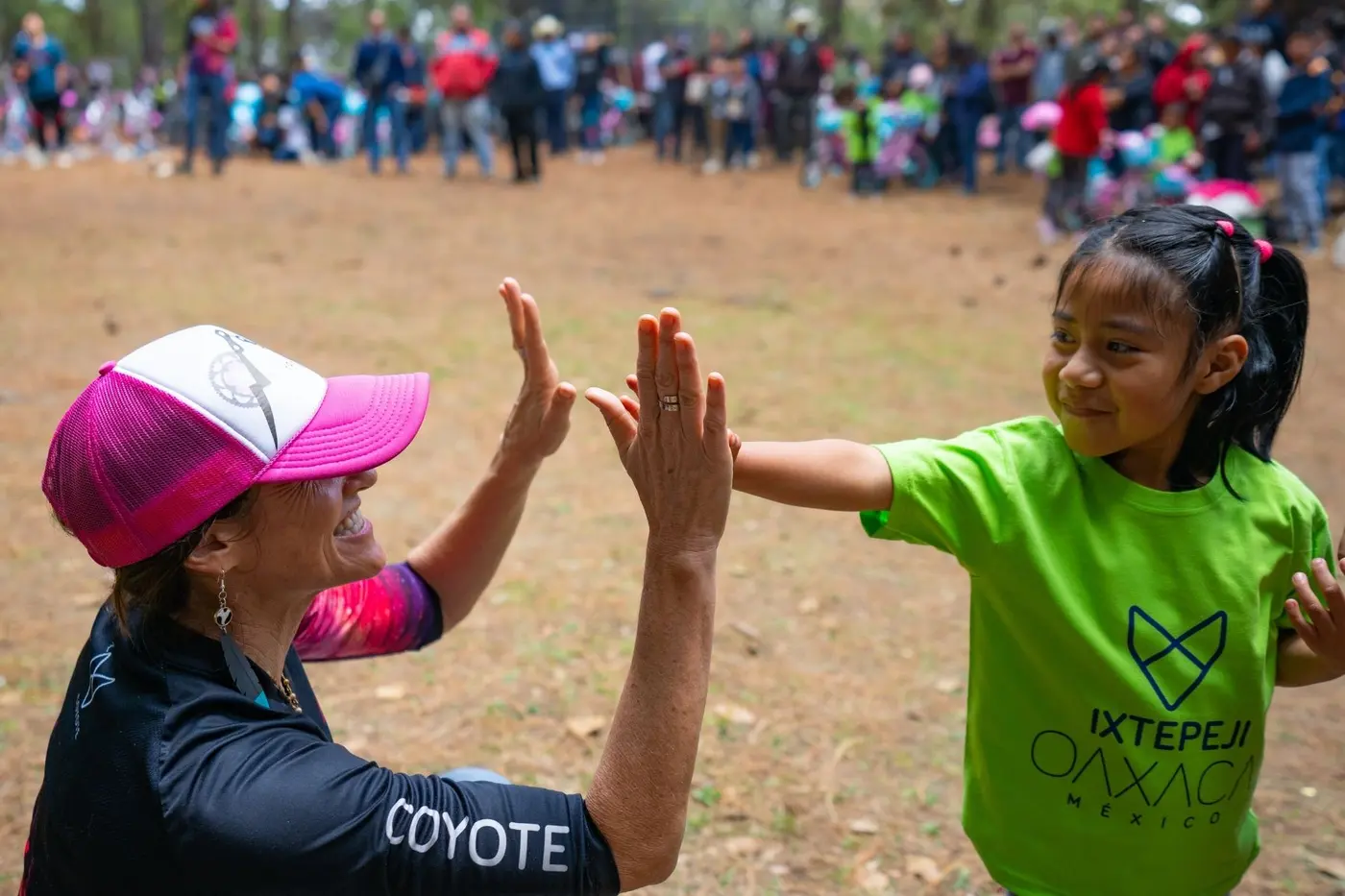 A coach high-fiving a young rider